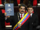 Nicolás Maduro durante a cerimônia de posse presidencial em 2019, vestido com terno escuro e faixa presidencial, discursando diante de bandeiras da Venezuela.