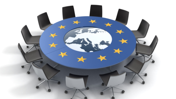 Mesa redonda da União Europeia com cadeiras ao redor, destacando o mapa da Europa e estrelas do bloco, representando a reunião informal de líderes da UE em 24 de novembro de 2025