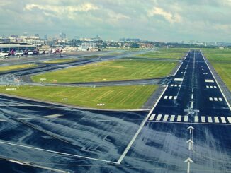 Pista 25R do Aeroporto de Bruxelas vista ao entardecer, com luzes de balizamento acesas e tráfego aéreo intenso.