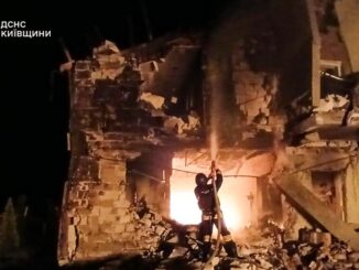 Bombeiro ucraniano combate incêndio em prédio residencial destruído após ataque em Zaporizhzhia, com danos extensos e vítimas civis.