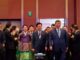 Presidente chinês Xi Jinping e presidente sul-coreano caminhando juntos em evento da APEC 2025, cercados por delegados e assessores.
