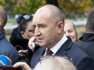 Presidente da Bulgária, Rumen Radev, falando com jornalistas ao ar livre, cercado por repórteres e microfones.