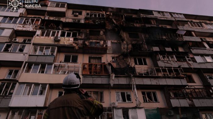 Equipes de emergência ucranianas atuam entre escombros após ataques russos noturnos em Kiev.
