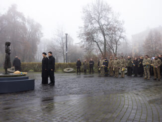Presidente ucraniano e militares em homenagem às vítimas do Holodomor em Kiev, com velas e flores em meio à neblina