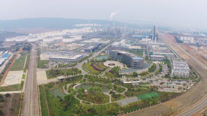Instalação petroquímica da PetroChina em Yunnan, vista aérea de prédios industriais, torres e infraestrutura pesada.