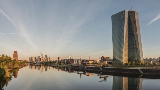 Skyline de Frankfurt ao amanhecer com a sede do Banco Central Europeu à esquerda, simbolizando a economia da zona do euro.