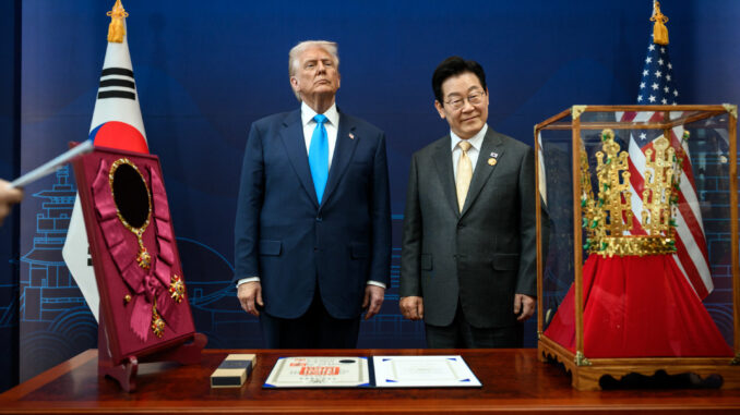 Presidente dos EUA Donald Trump e líder sul-coreano posam juntos durante cerimônia com condecoração e coroa tradicional entre as bandeiras dos dois países