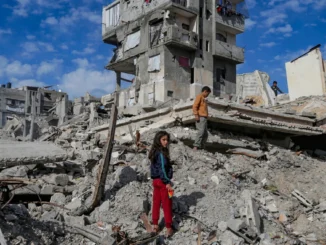 Duas crianças observam prédios destruídos após ataque na Faixa de Gaza.