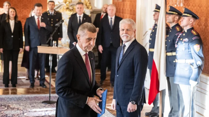 Andrej Babiš e o presidente da Chéquia em uma cerimônia oficial, com autoridades e guardas uniformizados ao fundo.