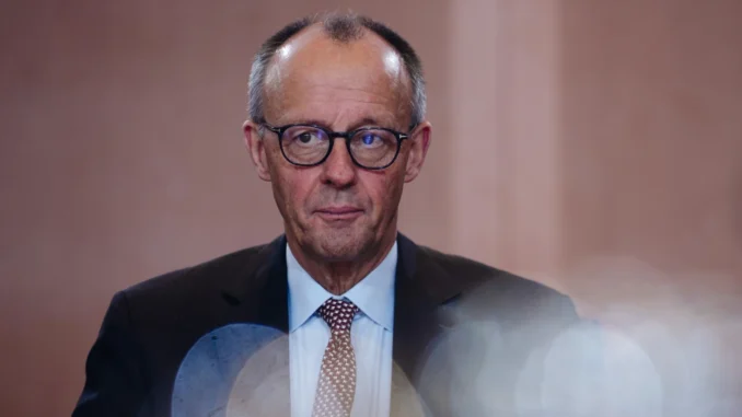 Friedrich Merz em pé, falando ao microfone, durante coletiva sobre segurança europeia — 2025.